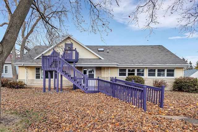 view of front of house with roof with shingles and stairs