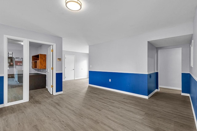 unfurnished room featuring baseboards and wood finished floors