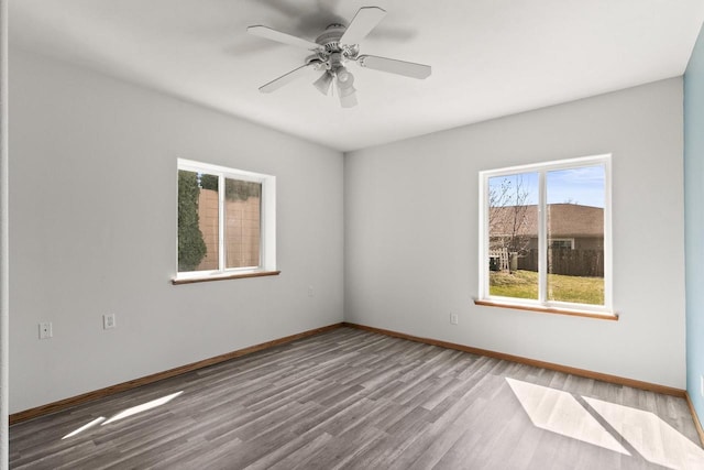 spare room featuring wood finished floors, baseboards, and a ceiling fan