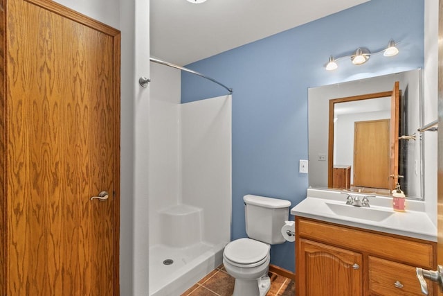 bathroom featuring a shower stall, vanity, tile patterned flooring, and toilet
