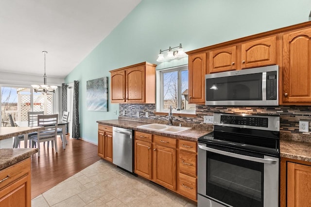 kitchen featuring a chandelier, dark countertops, a sink, and stainless steel appliances