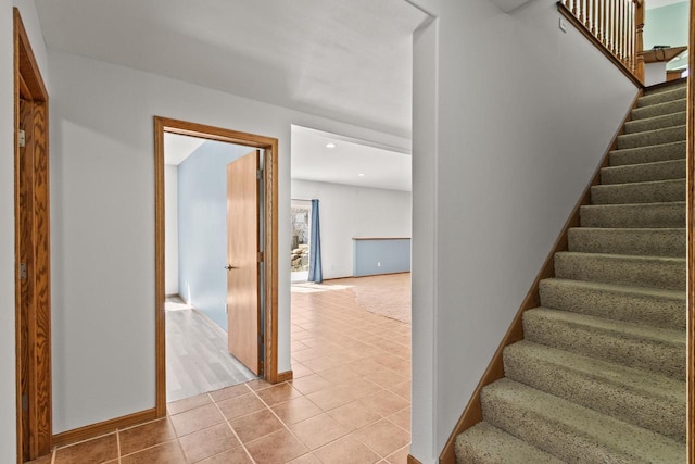 stairs featuring tile patterned floors and baseboards
