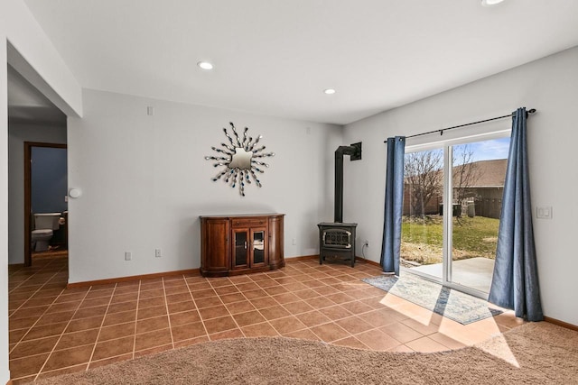 interior space with light tile patterned floors, baseboards, recessed lighting, and a wood stove