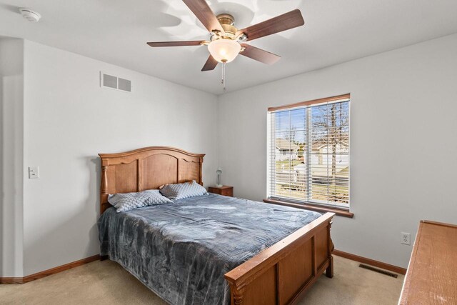 bedroom featuring ceiling fan, light colored carpet, baseboards, and visible vents