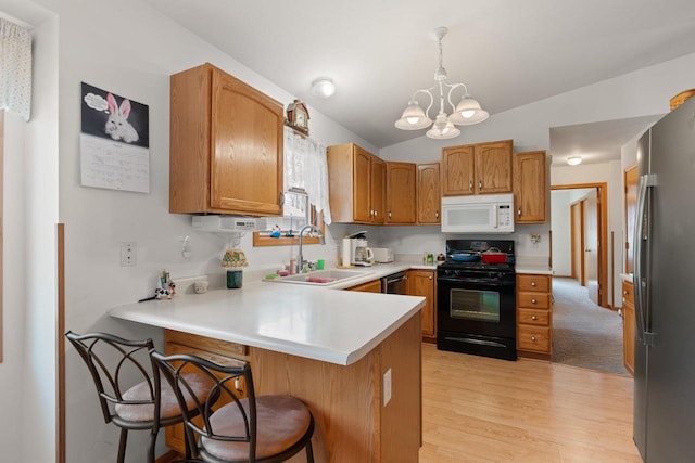 509 Meadow View Rd, Mount Horeb, WI 53572 - kitchen featuring an inviting chandelier, a sink, light wood-type flooring, black appliances, and a peninsula