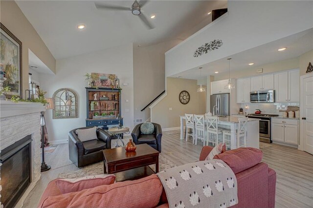 102 Linden Ave, Hudson, WI 54016 - living room with a stone fireplace, baseboards, light wood-style floors, and ceiling fan
