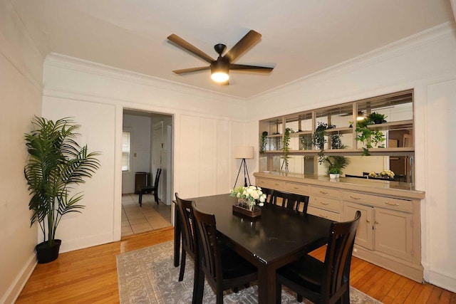 dining space featuring light wood-type flooring, ceiling fan, and ornamental molding