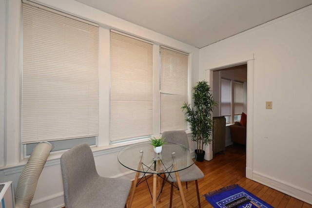 dining space featuring baseboards and hardwood / wood-style flooring