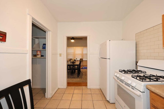 kitchen featuring light countertops, gas range gas stove, ceiling fan, light tile patterned floors, and decorative backsplash