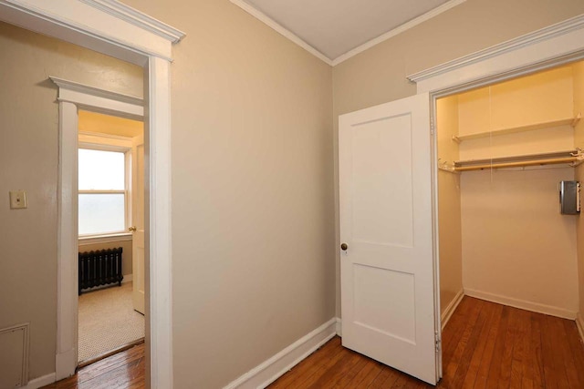 hallway featuring radiator heating unit, ornamental molding, and hardwood / wood-style floors
