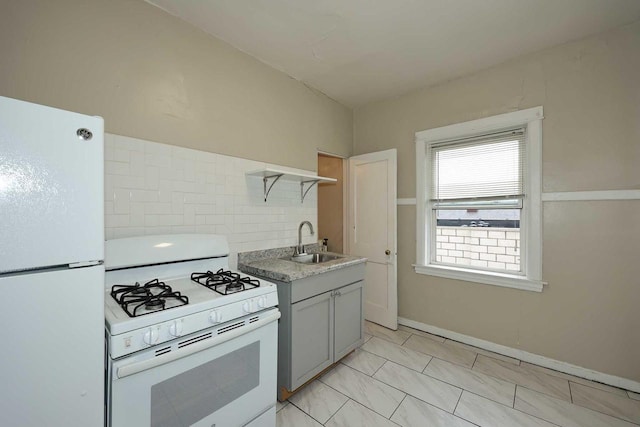 kitchen featuring light countertops, a sink, gray cabinetry, and white appliances