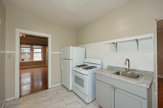 kitchen featuring backsplash, a sink, and white gas stove