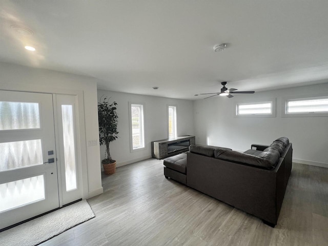 living room with baseboards, light wood-type flooring, ceiling fan, and recessed lighting