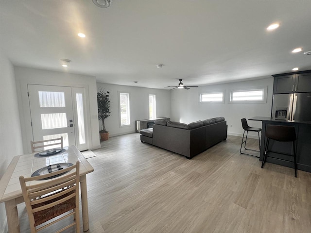living room with light wood-type flooring, ceiling fan, baseboards, and recessed lighting