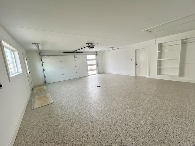 garage featuring a garage door opener and baseboards