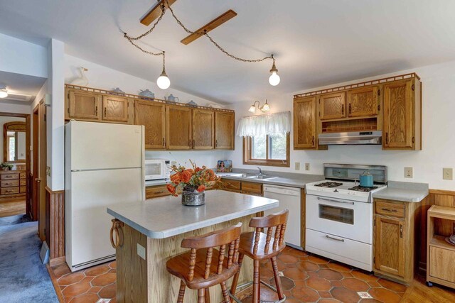 W5854 Bubbling Springs Dr, Elkhorn, WI 53121 - kitchen with brown cabinetry, under cabinet range hood, a sink, and white appliances