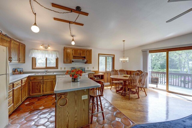 W5854 Bubbling Springs Dr, Elkhorn, WI 53121 - kitchen with range hood, a center island, light countertops, a sink, and brown cabinets