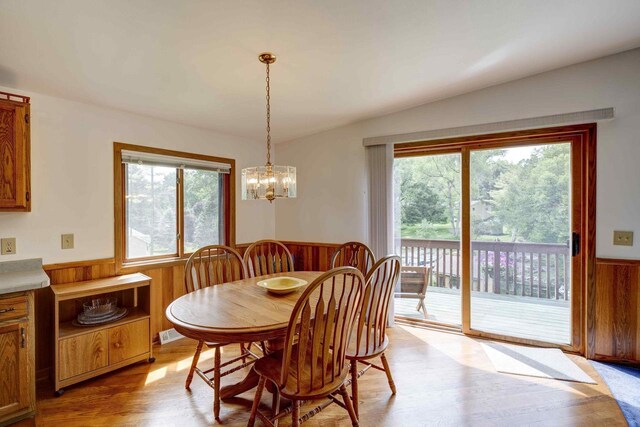 W5854 Bubbling Springs Dr, Elkhorn, WI 53121 - dining space featuring light wood-style floors, visible vents, wood walls, wainscoting, and a notable chandelier
