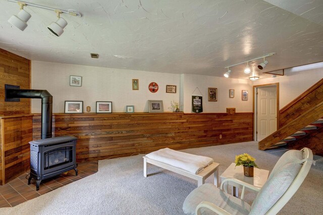 W5854 Bubbling Springs Dr, Elkhorn, WI 53121 - tiled living area with wooden walls, rail lighting, stairway, and a wood stove