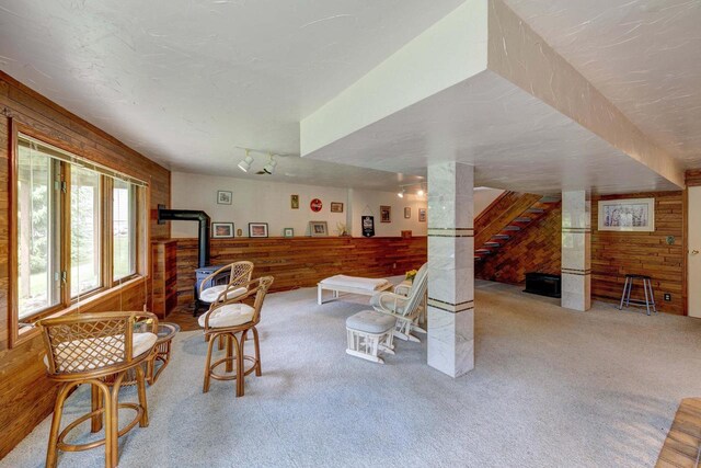 W5854 Bubbling Springs Dr, Elkhorn, WI 53121 - sitting room with wooden walls, a wood stove, stairway, and carpet