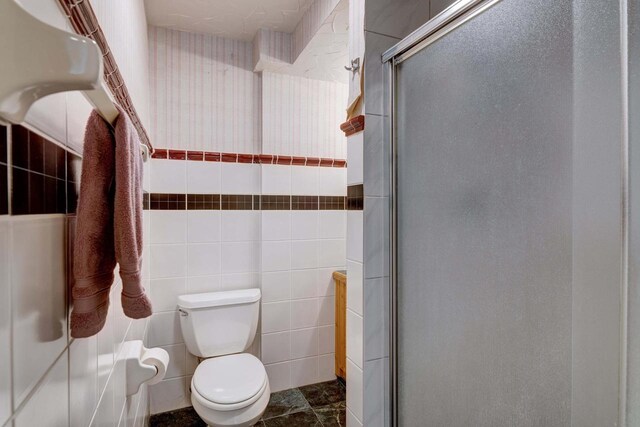 W5854 Bubbling Springs Dr, Elkhorn, WI 53121 - full bathroom featuring toilet, tile walls, and a stall shower