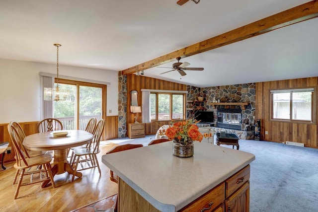 W5854 Bubbling Springs Dr, Elkhorn, WI 53121 - kitchen featuring ceiling fan with notable chandelier, wooden walls, vaulted ceiling with beams, and plenty of natural light