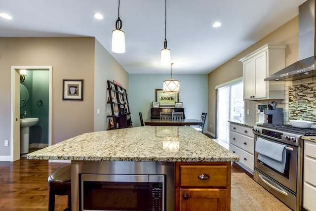 6679 S Chickahauk Trl, Middleton, WI 53562 - kitchen with stainless steel appliances, wall chimney exhaust hood, dark wood finished floors, tasteful backsplash, and white cabinetry