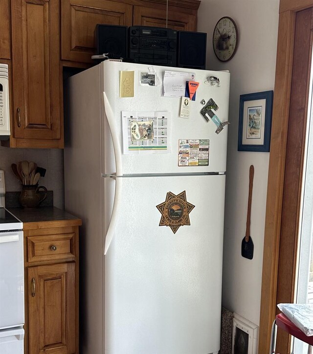 7533 N Evergreen Dr, Algoma, WI 54201 - kitchen with brown cabinets, backsplash, and white appliances