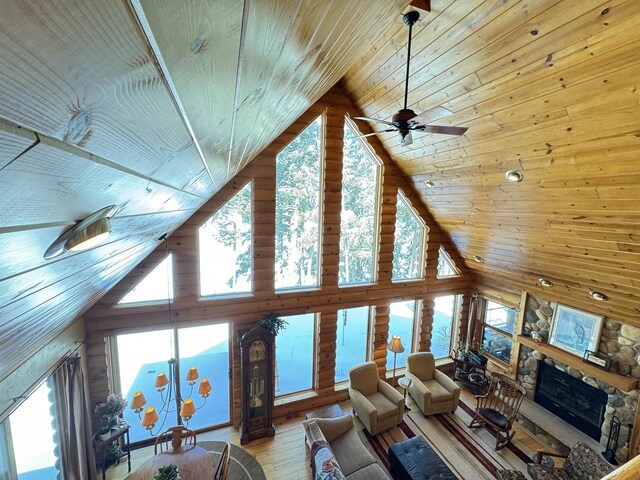 7118 Timber Ln, Rhinelander, WI 54501 - living room with wood-type flooring, high vaulted ceiling, a stone fireplace, and wood ceiling