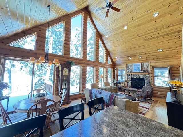 7118 Timber Ln, Rhinelander, WI 54501 - dining room with rustic walls, hardwood / wood-style floors, wooden ceiling, high vaulted ceiling, and a stone fireplace