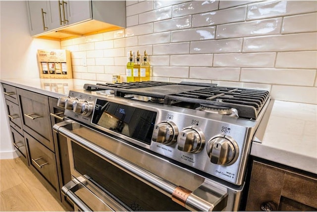11684 Brook Ln, Hayward, WI 54843 - kitchen featuring light wood-style flooring, range with two ovens, light countertops, and decorative backsplash