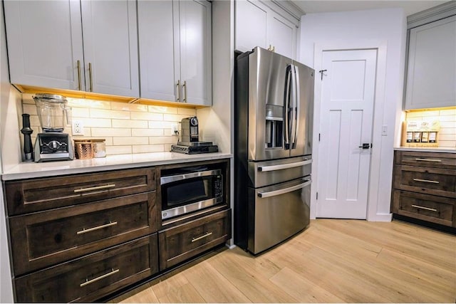11684 Brook Ln, Hayward, WI 54843 - kitchen featuring dark brown cabinetry, light wood-style flooring, light countertops, backsplash, and appliances with stainless steel finishes
