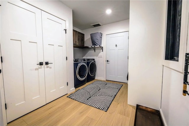 11684 Brook Ln, Hayward, WI 54843 - laundry room featuring separate washer and dryer, light wood finished floors, cabinet space, and visible vents