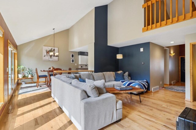 119 Vilas Hibbard Pkwy, Lodi, WI 53555 - living room featuring high vaulted ceiling, a notable chandelier, visible vents, and light wood-style flooring