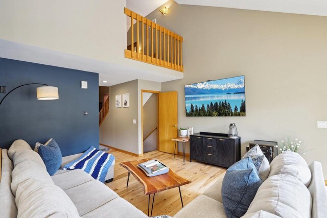 119 Vilas Hibbard Pkwy, Lodi, WI 53555 - living room featuring light wood finished floors, baseboards, a towering ceiling, and stairway