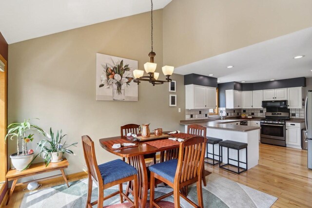 119 Vilas Hibbard Pkwy, Lodi, WI 53555 - dining area featuring a chandelier, baseboards, recessed lighting, lofted ceiling, and light wood-style floors