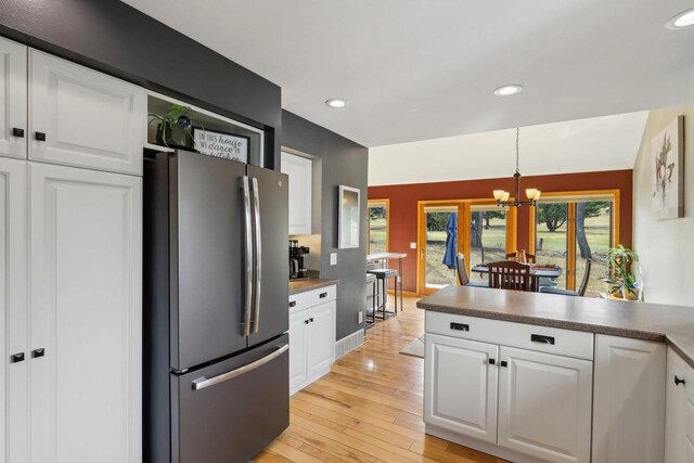 119 Vilas Hibbard Pkwy, Lodi, WI 53555 - kitchen featuring white cabinetry, a chandelier, light wood-style floors, and freestanding refrigerator