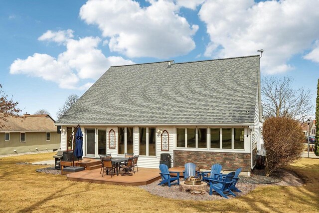 119 Vilas Hibbard Pkwy, Lodi, WI 53555 - back of house with stone siding, a patio, an outdoor fire pit, roof with shingles, and a yard