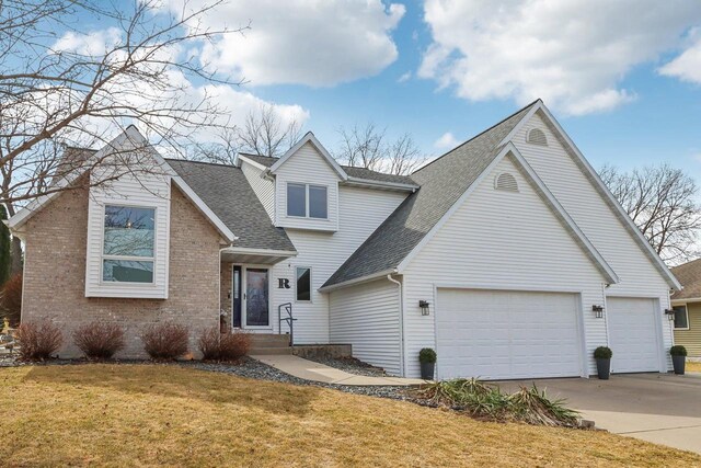 119 Vilas Hibbard Pkwy, Lodi, WI 53555 - traditional-style house featuring a garage, concrete driveway, a front yard, brick siding, and roof with shingles