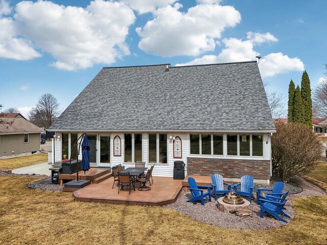 119 Vilas Hibbard Pkwy, Lodi, WI 53555 - back of property with a fire pit, roof with shingles, stone siding, and a yard