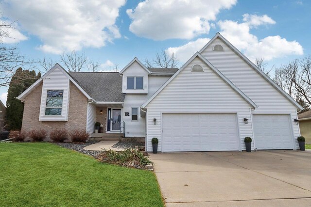 119 Vilas Hibbard Pkwy, Lodi, WI 53555 - view of front of house featuring a garage, concrete driveway, brick siding, a front lawn, and roof with shingles