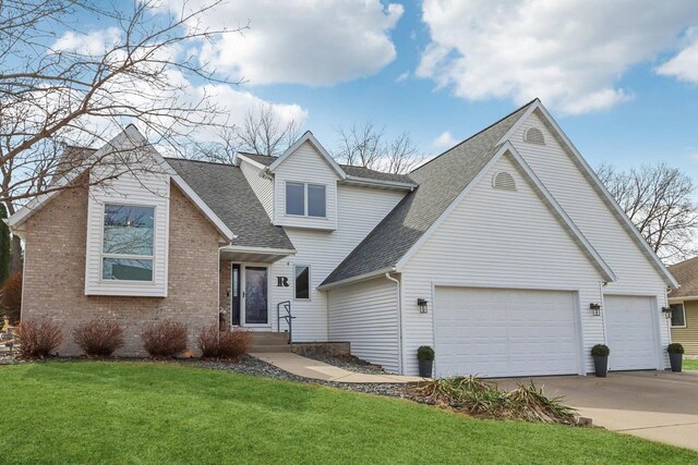 119 Vilas Hibbard Pkwy, Lodi, WI 53555 - view of front of home with a front yard, roof with shingles, concrete driveway, brick siding, and a garage