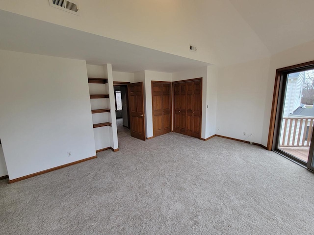 2215 N Shore Dr, Delavan, WI 53115 - empty room featuring baseboards, high vaulted ceiling, visible vents, and light carpet