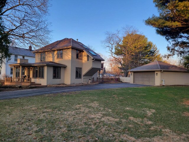 2215 N Shore Dr, Delavan, WI 53115 - rear view of property featuring an outdoor structure, driveway, a deck, a garage, and a lawn