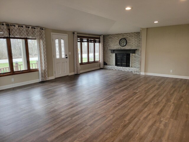2215 N Shore Dr, Delavan, WI 53115 - unfurnished living room with dark wood-style flooring, a brick fireplace, baseboards, and recessed lighting