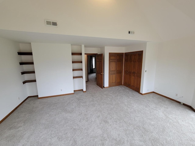 2215 N Shore Dr, Delavan, WI 53115 - unfurnished bedroom featuring light carpet, baseboards, visible vents, and high vaulted ceiling