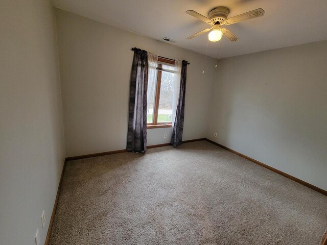 2215 N Shore Dr, Delavan, WI 53115 - spare room featuring baseboards, visible vents, ceiling fan, and carpet flooring