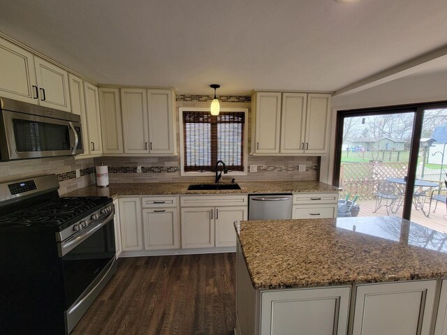 2215 N Shore Dr, Delavan, WI 53115 - kitchen with decorative backsplash, appliances with stainless steel finishes, dark wood-type flooring, a sink, and light stone counters