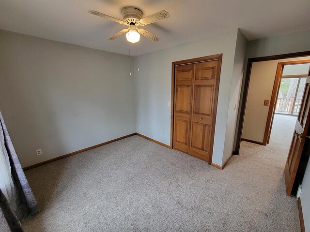 2215 N Shore Dr, Delavan, WI 53115 - unfurnished bedroom featuring light carpet, baseboards, a closet, and a ceiling fan