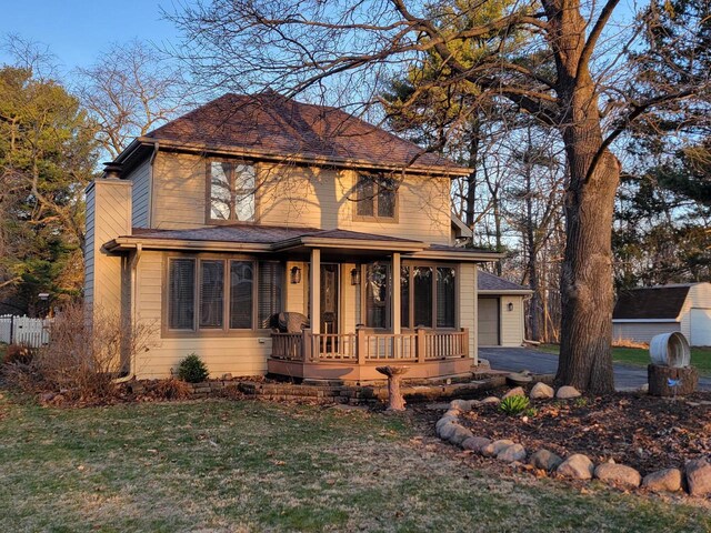 2215 N Shore Dr, Delavan, WI 53115 - view of front of home featuring a front yard, covered porch, a garage, and aphalt driveway